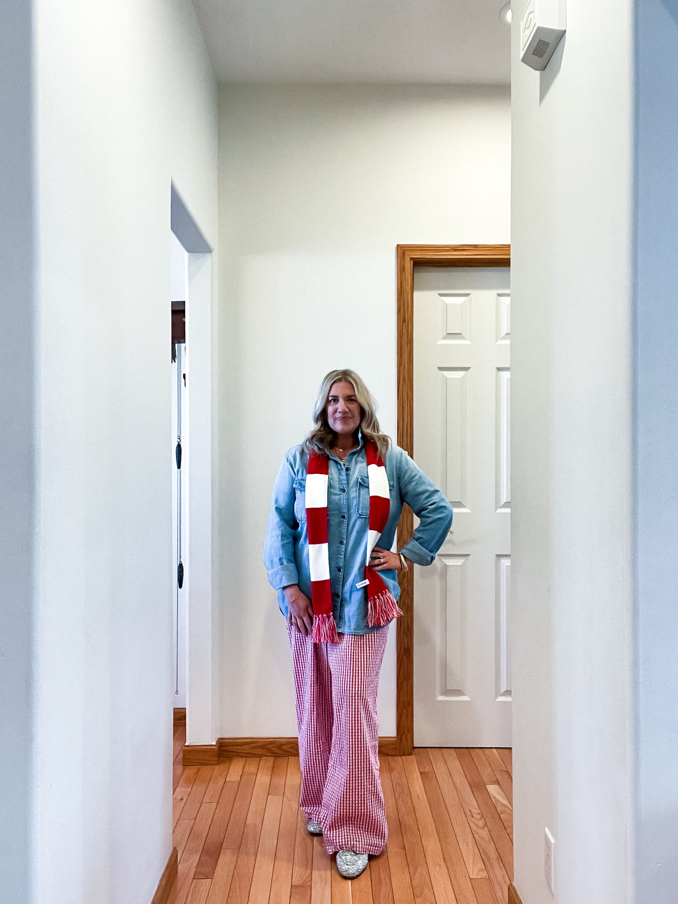 outfit inspiration: woman in a denim/chambray shirt, red and white pajama style pants, red and white striped scarf, and sparkly Gucci mules