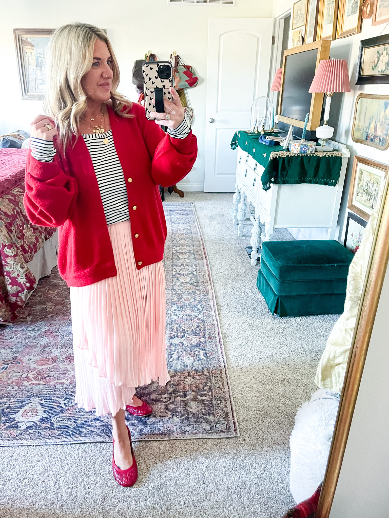 woman in a red sweater, black and white striped shirt, pink chiffon skirt, and red ballet flats