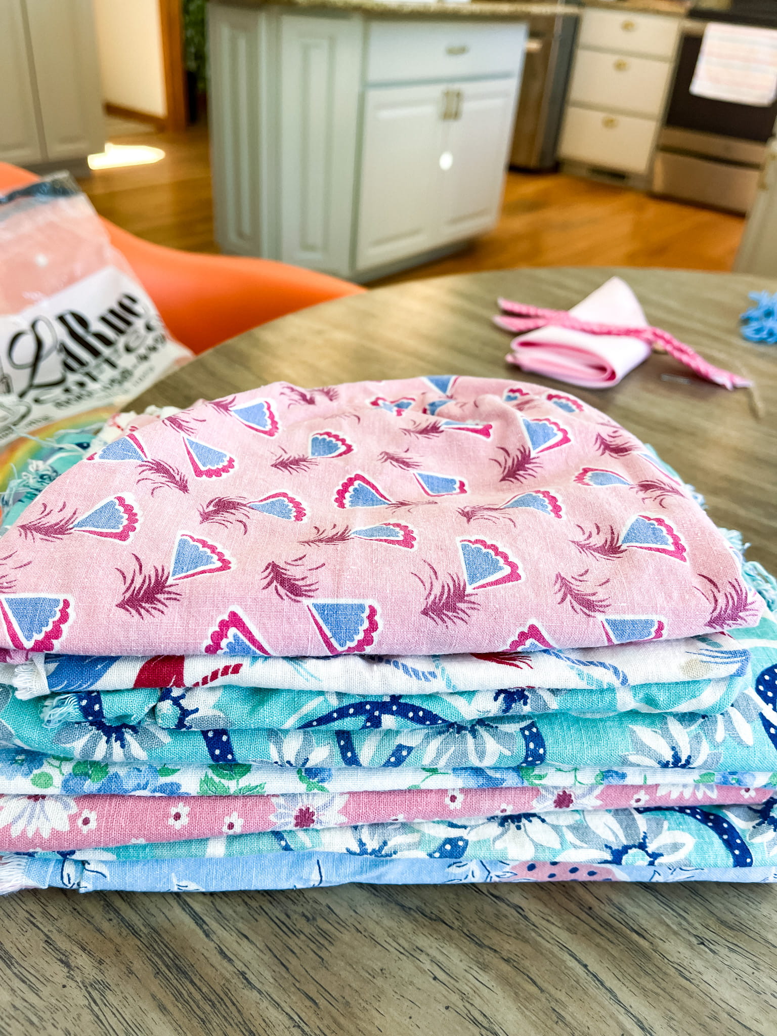 Stack of colorful vintage flour sack fabric