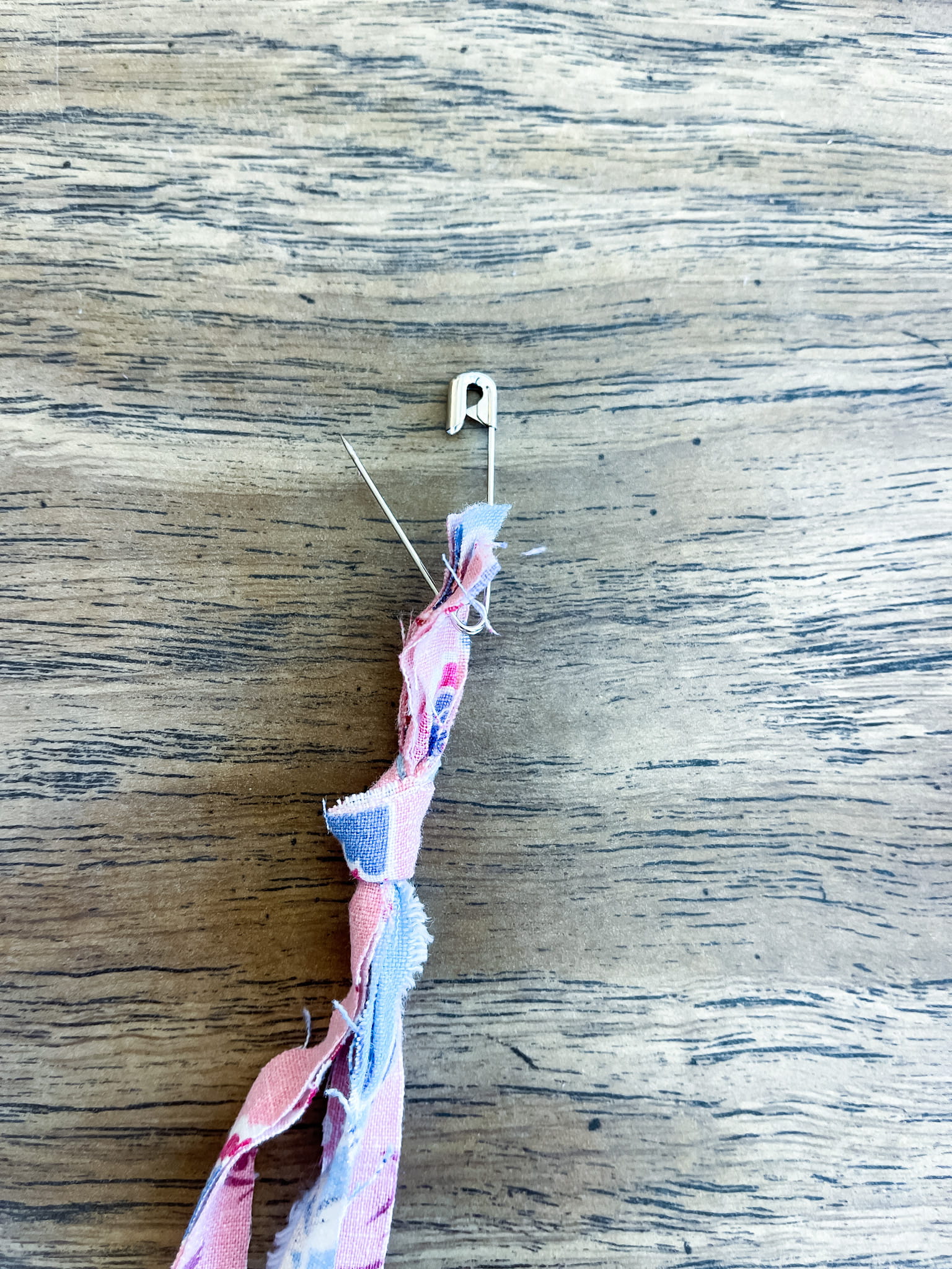 strips of fabric tied together with a safety pin in the end