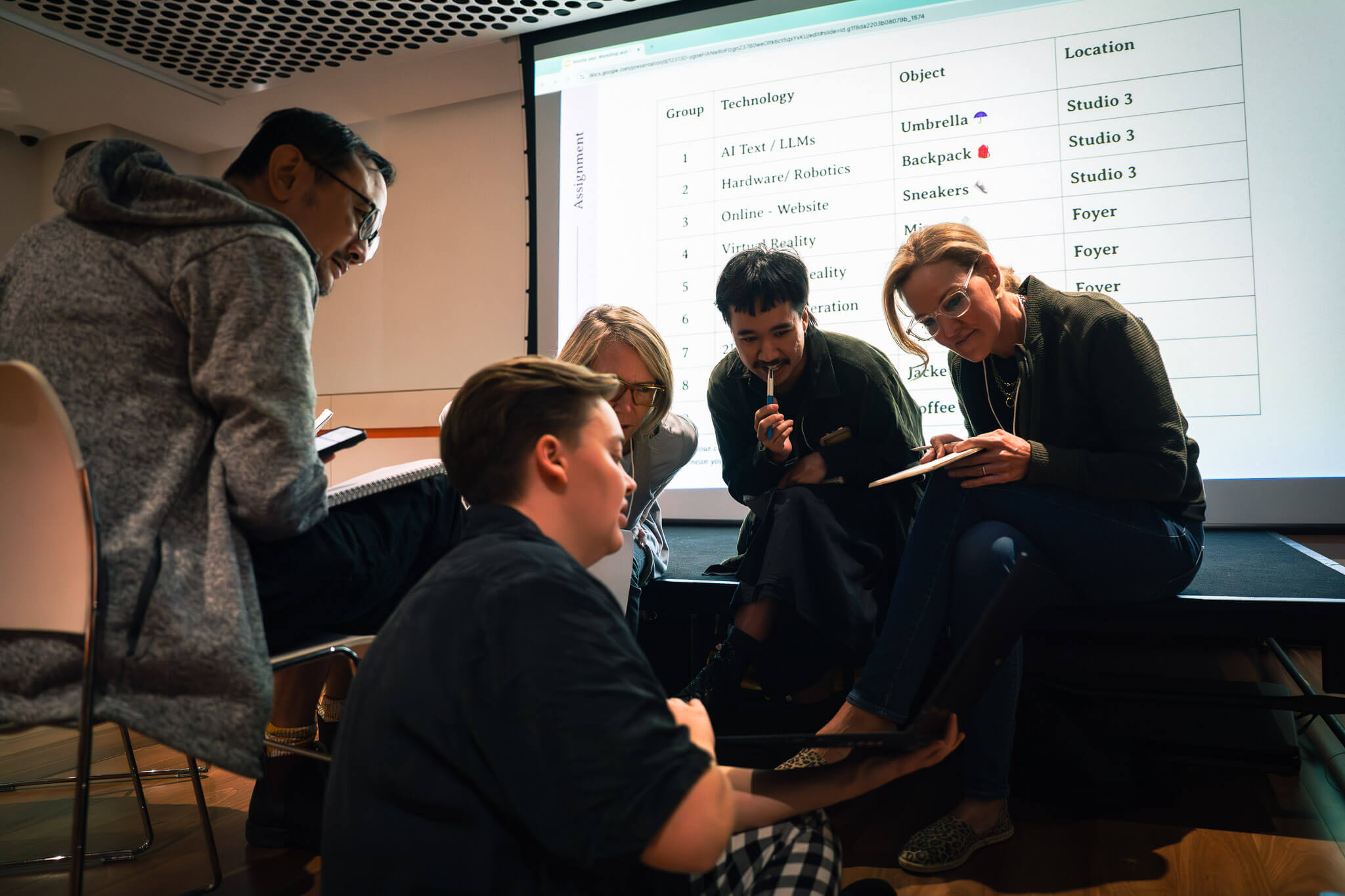 A group of people sitting reading a document together