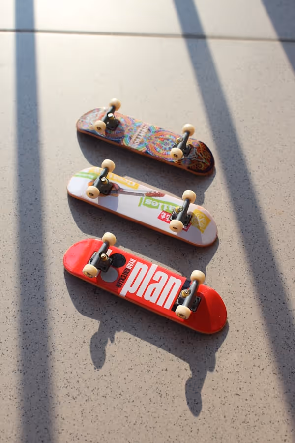 Tech Deck skateboards chilling in the sun in a cool position, creating very poetic shadows.
