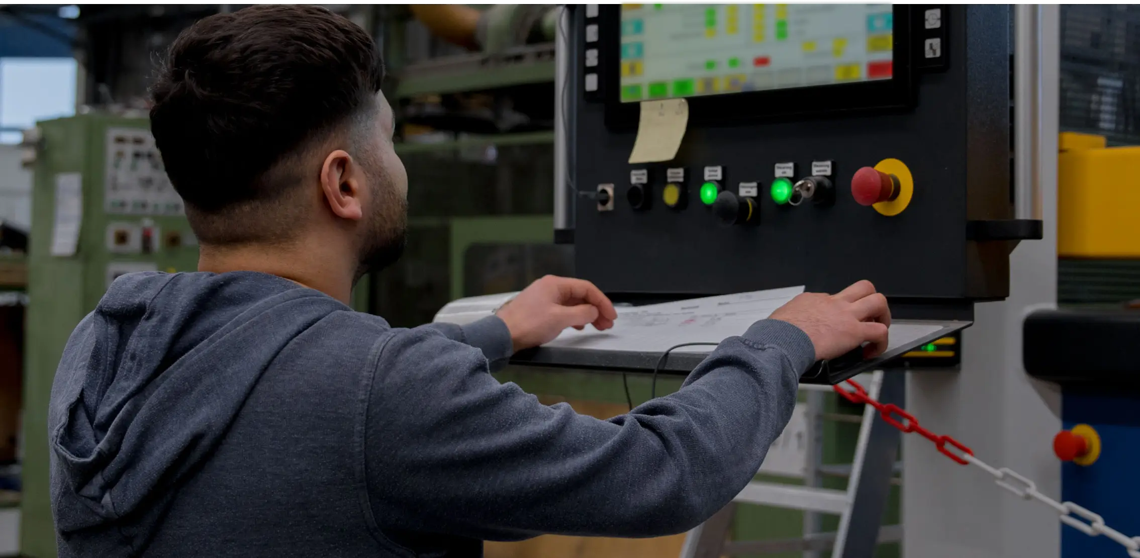 Mitarbeiter männlich bedient Anlage von Reku Thermoforming