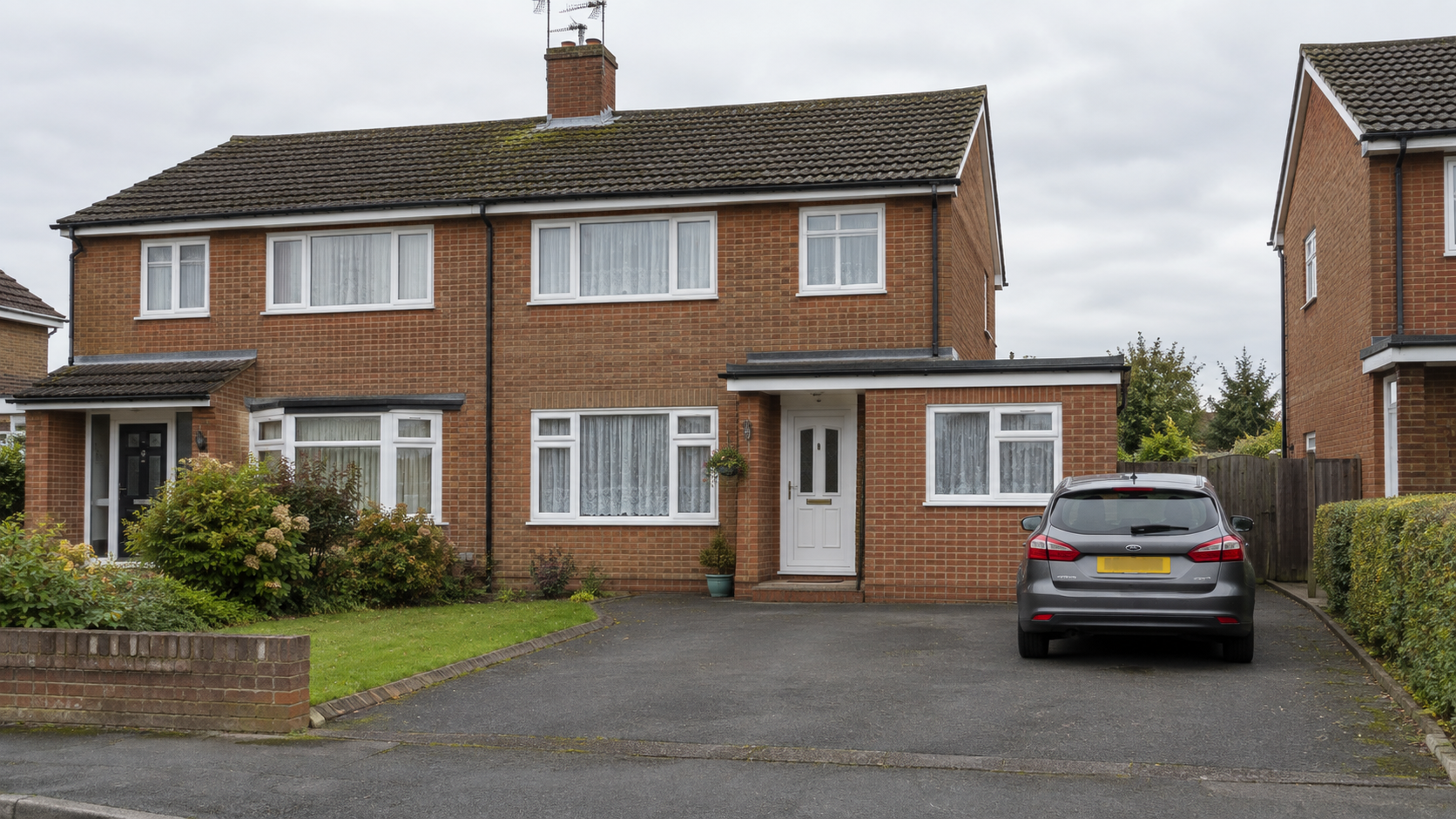 UK semi-detached house with garage converted, brick infill and new window matching the original house