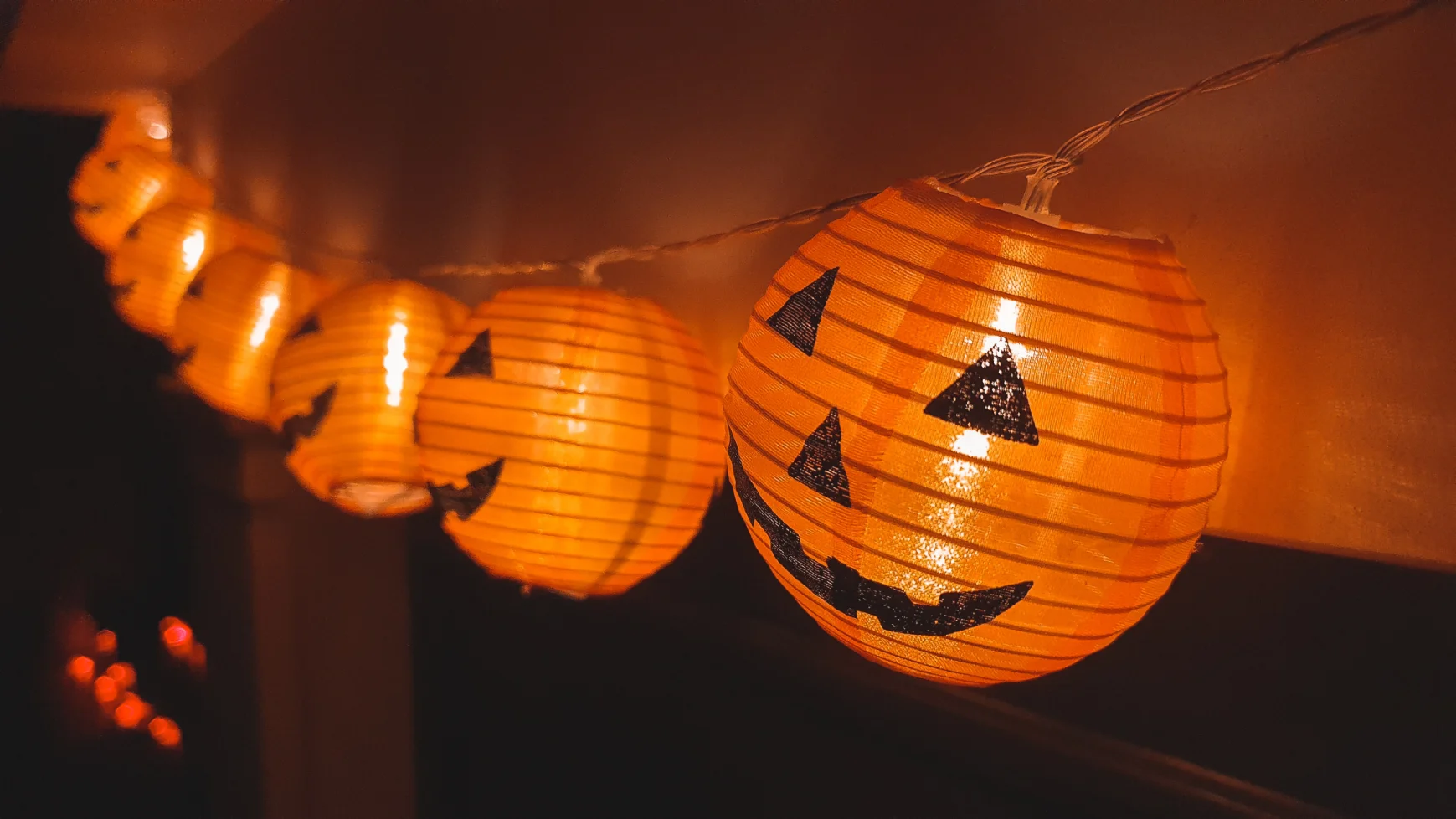 A string of lights with jack-o-lantern faces.