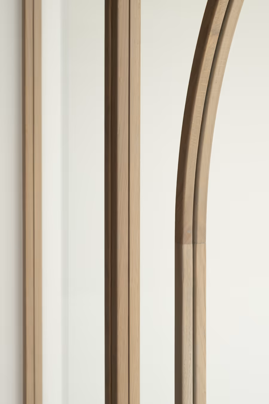 Karakteristieke glazen deur met warme, licht houten latten die het glas in meerdere vlakken verdeeld.