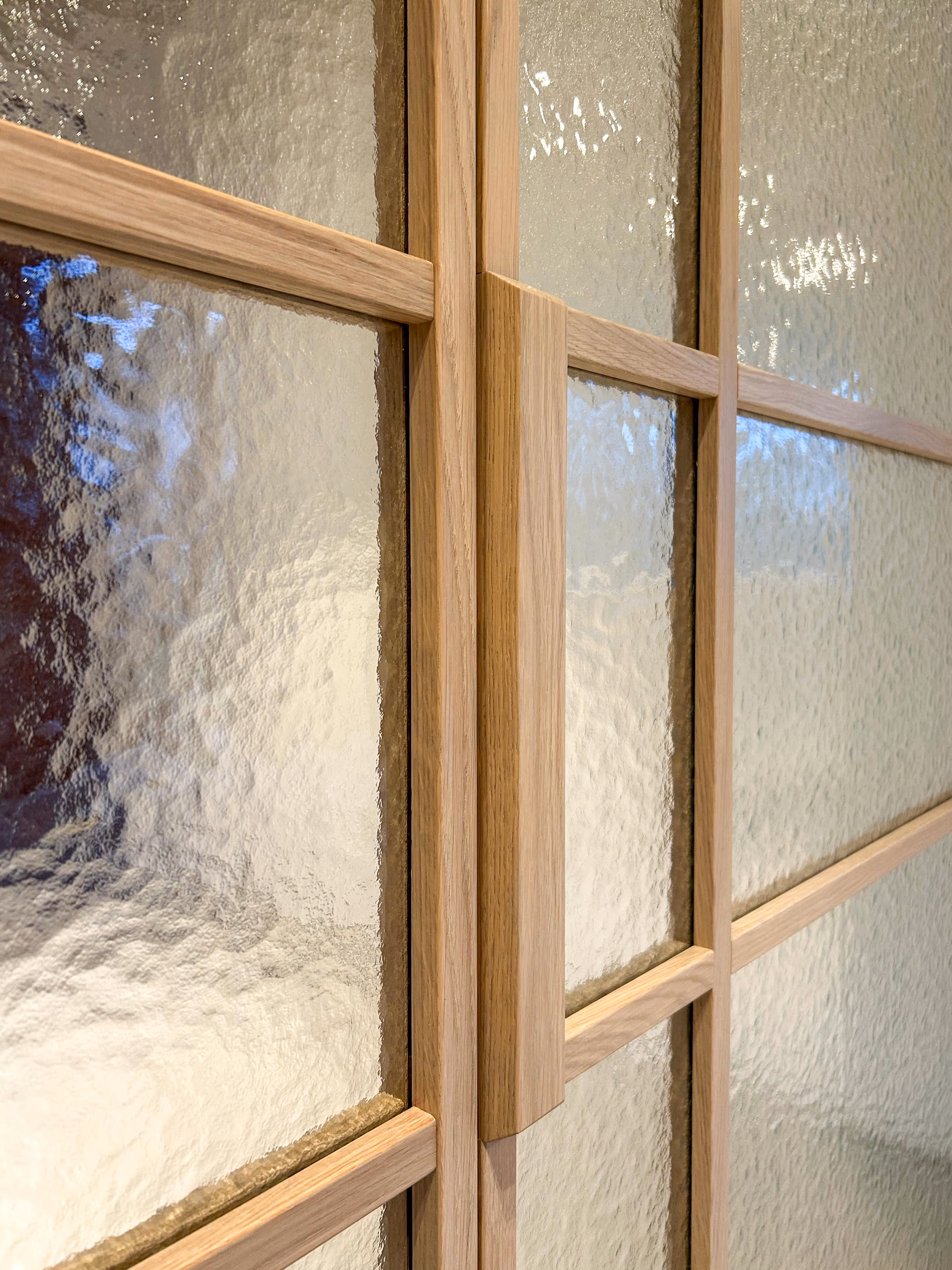 Close-up van deurpanelen met houten latten en figuurglas.