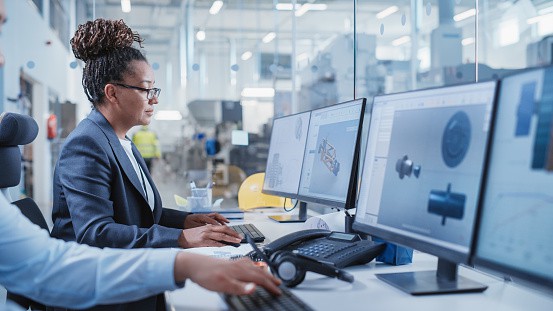 Factory Office Facility: Industrial Engineers Drafting Blueprints of a Heavy Industry Machine Parts on a Computer CAD Software. Modern Technological Industry 4.0 Research and Development Center.