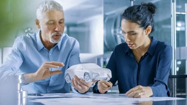 Two people looking at a 3D model of a car