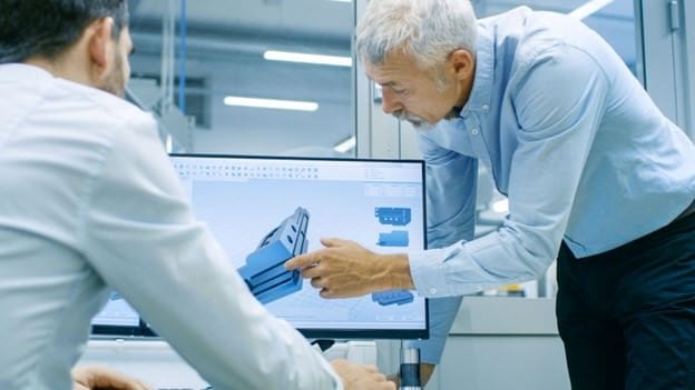 Two men looking at a 3D model on a computer screen