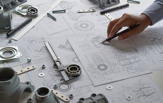 Engineer technician designing drawings mechanicalÂ parts engineering Engine manufacturing factory Industry Industrial work project blueprints measuring bearings caliper tools