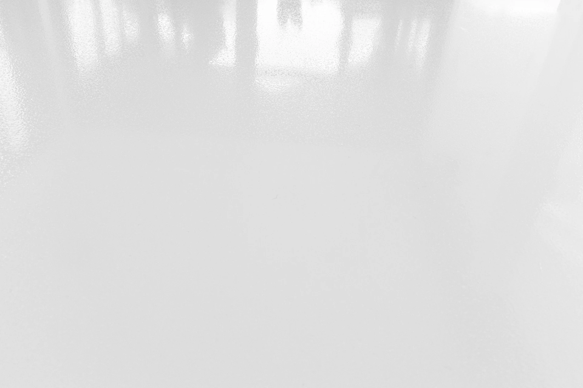 Close-up of a sleek white solid epoxy coating in a residential garage, highlighting its durable, reflective surface.