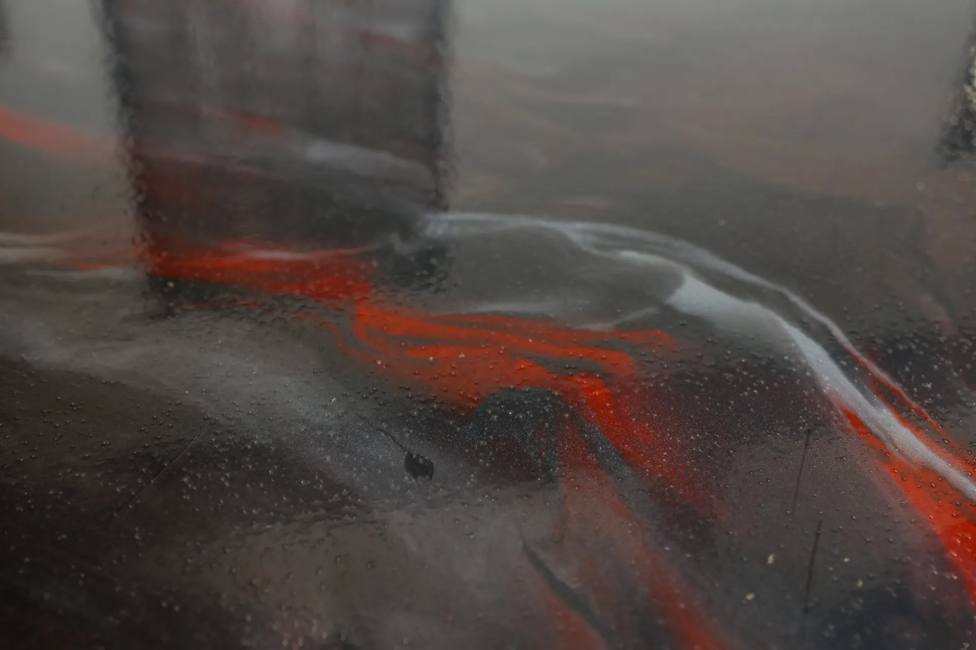 Close-up of high-gloss metallic epoxy floor showing custom color blend of red, charcoal, and pearl at Holmes Manufacturing.