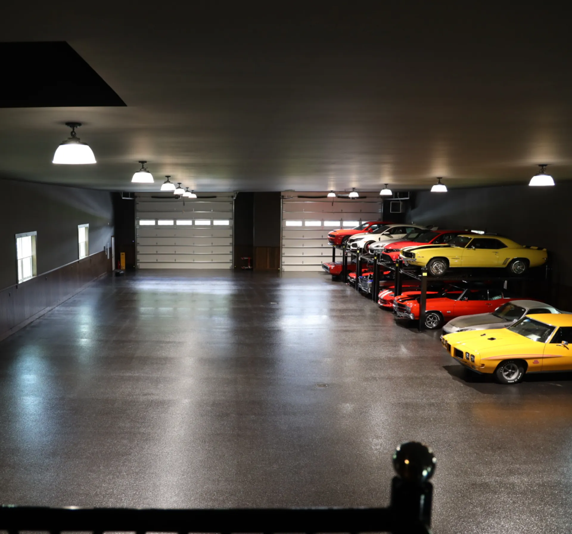 full view of garage with new floor coating. Racks of vintage cars on the right side