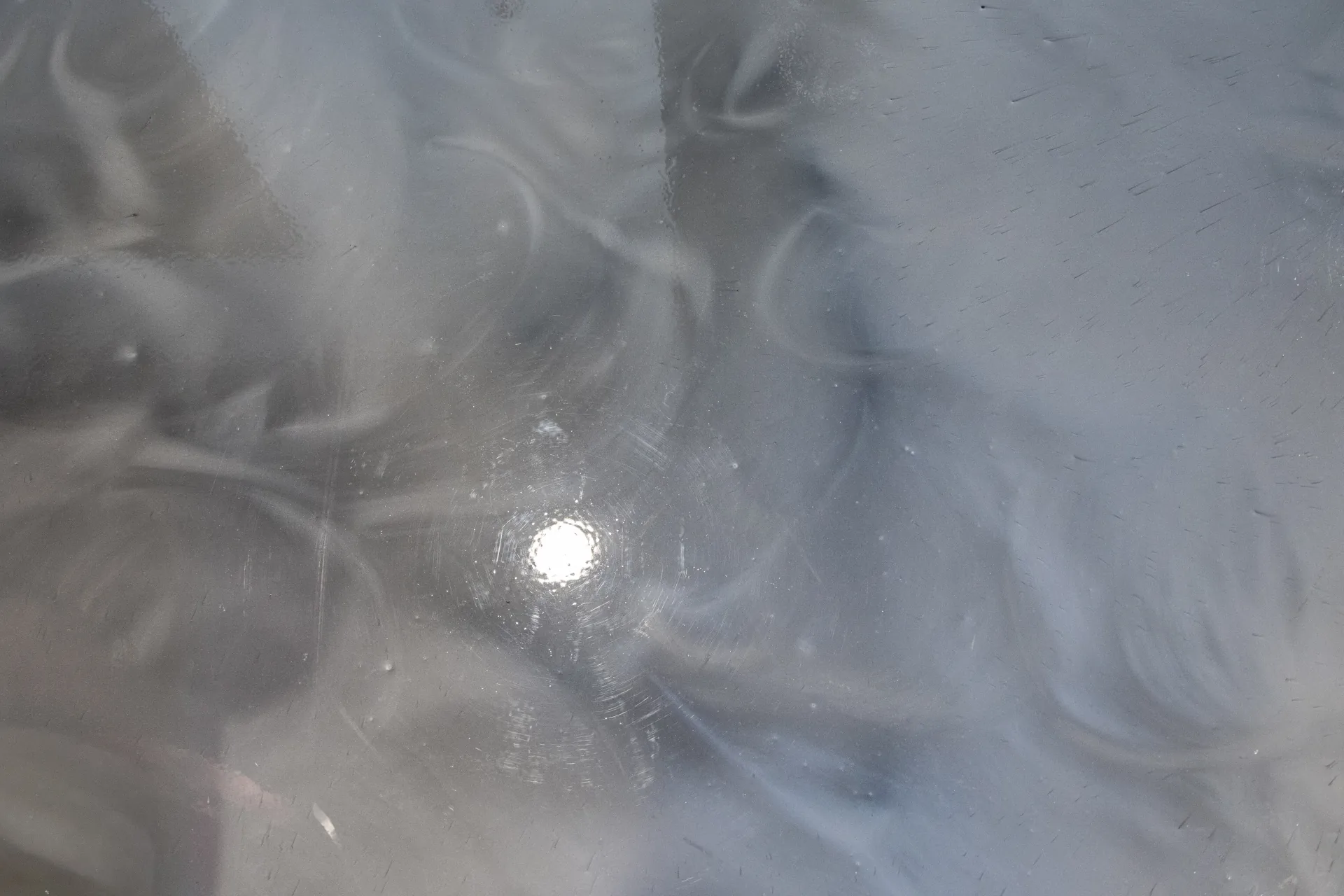 Close-up of swirling metallic epoxy pattern with high-gloss reflection.