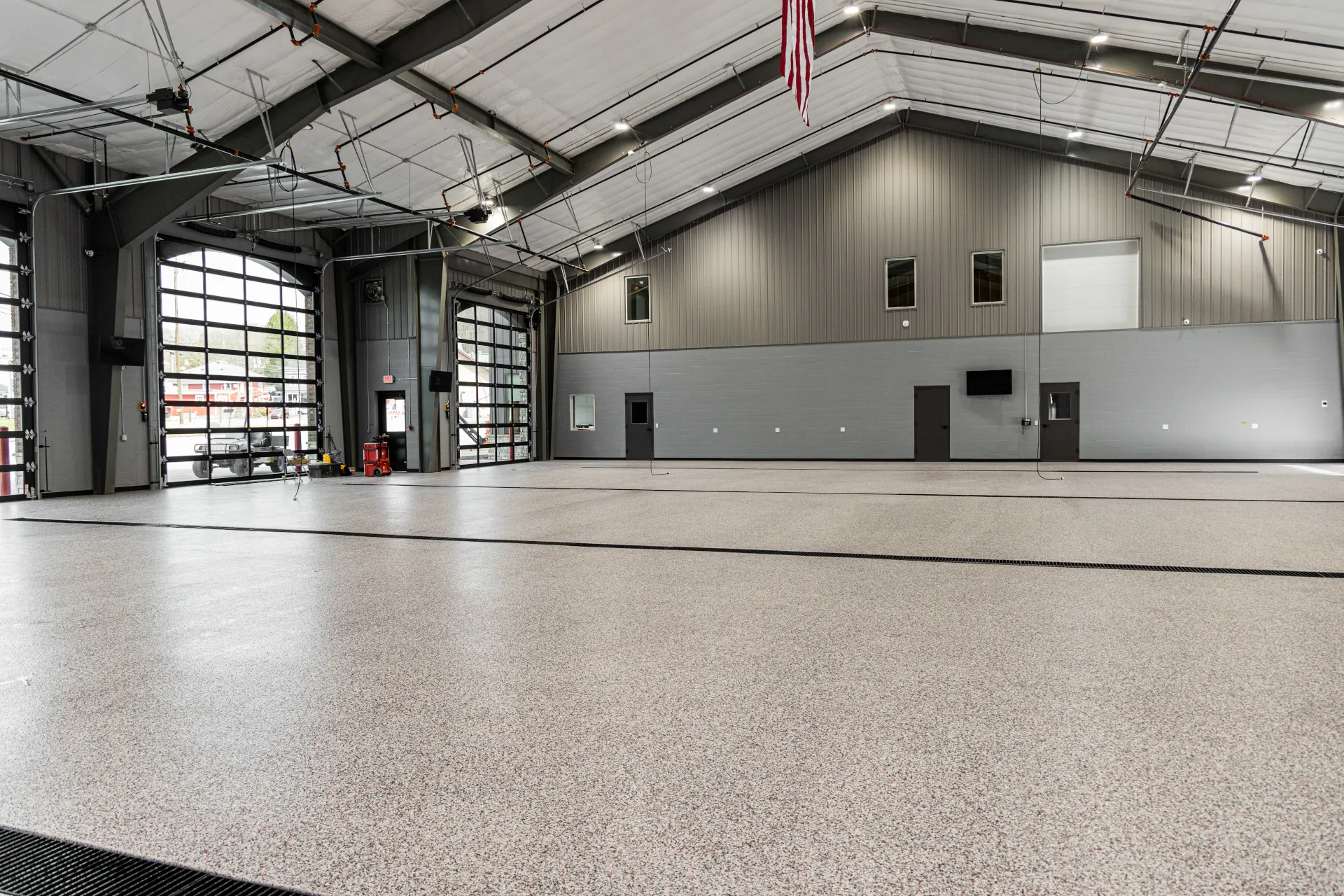 Large open fire station bay featuring seamless decorative flake flooring installed by Superior Floor Coatings.