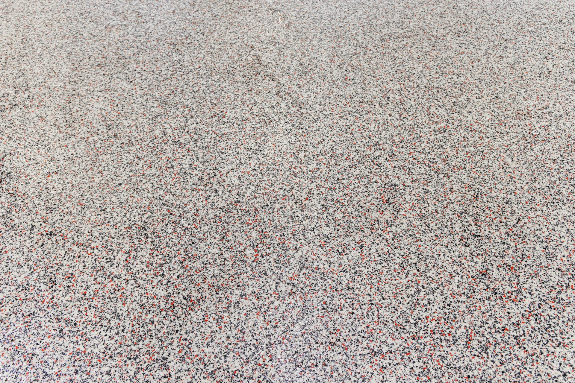 Close-up detail of decorative flake floor coating installed at Fredericksburg Fire Station showing textured finish and color blend.