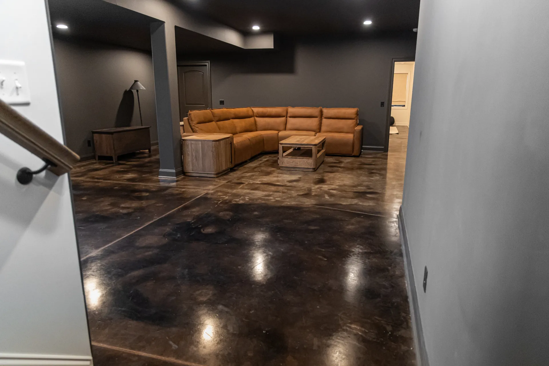 Residential basement featuring custom acid stain concrete flooring with rich marbled color variation and glossy finish.