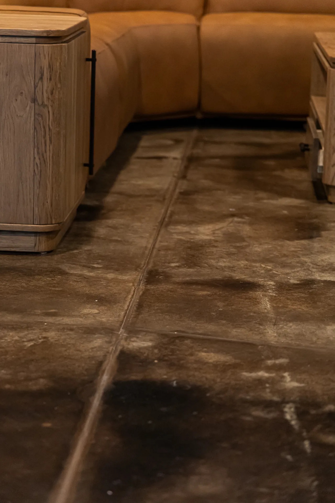 Close-up view of acid stain concrete flooring in residential basement showing natural marbled texture and sheen.