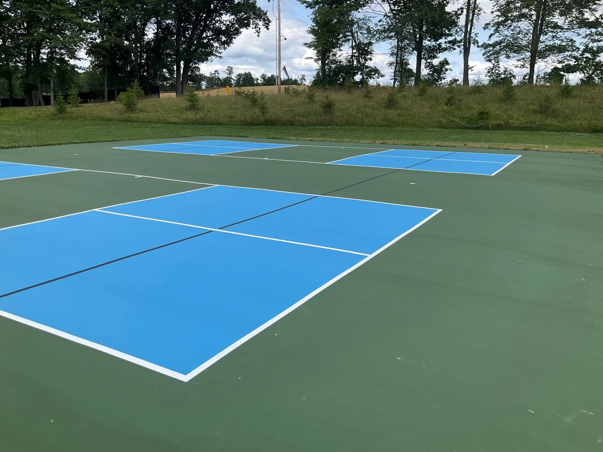Blue and green coated pickleball courts with freshly painted game lines
