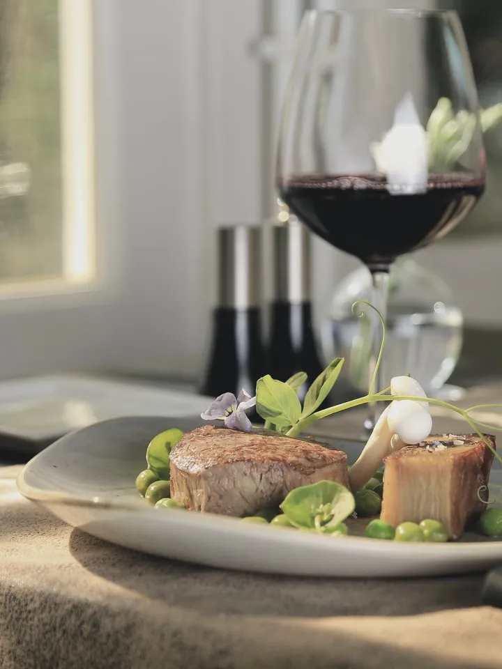A plated dish and a glass of red wine