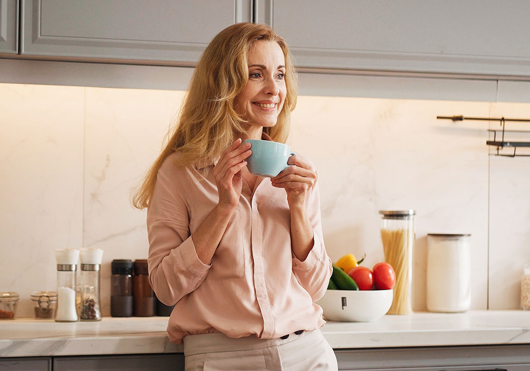 Charming Caucasian woman having positive breakfast in modern kitchen