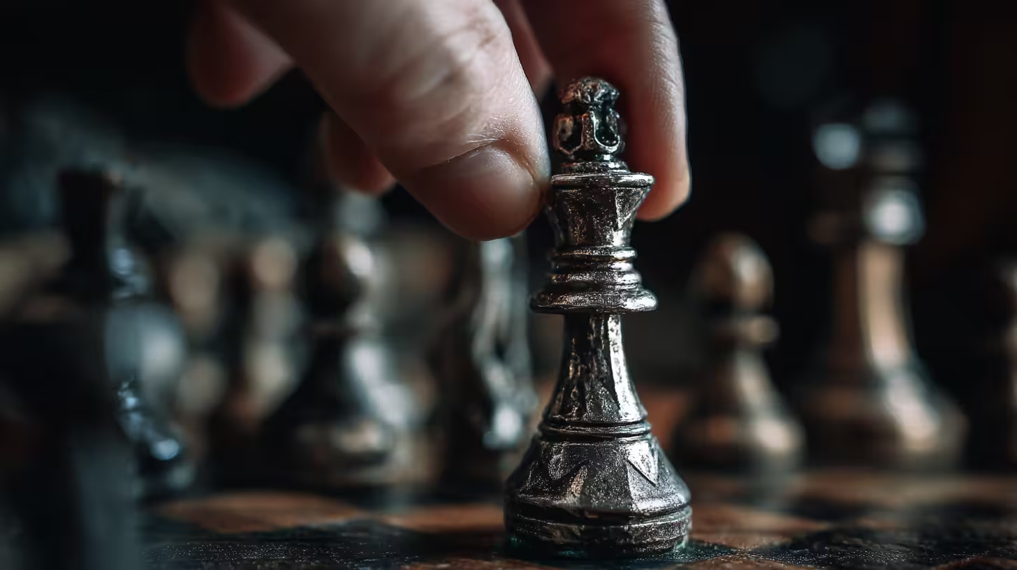 A queen chess piece held by a hand ready to move, representing leadership coaching for women.