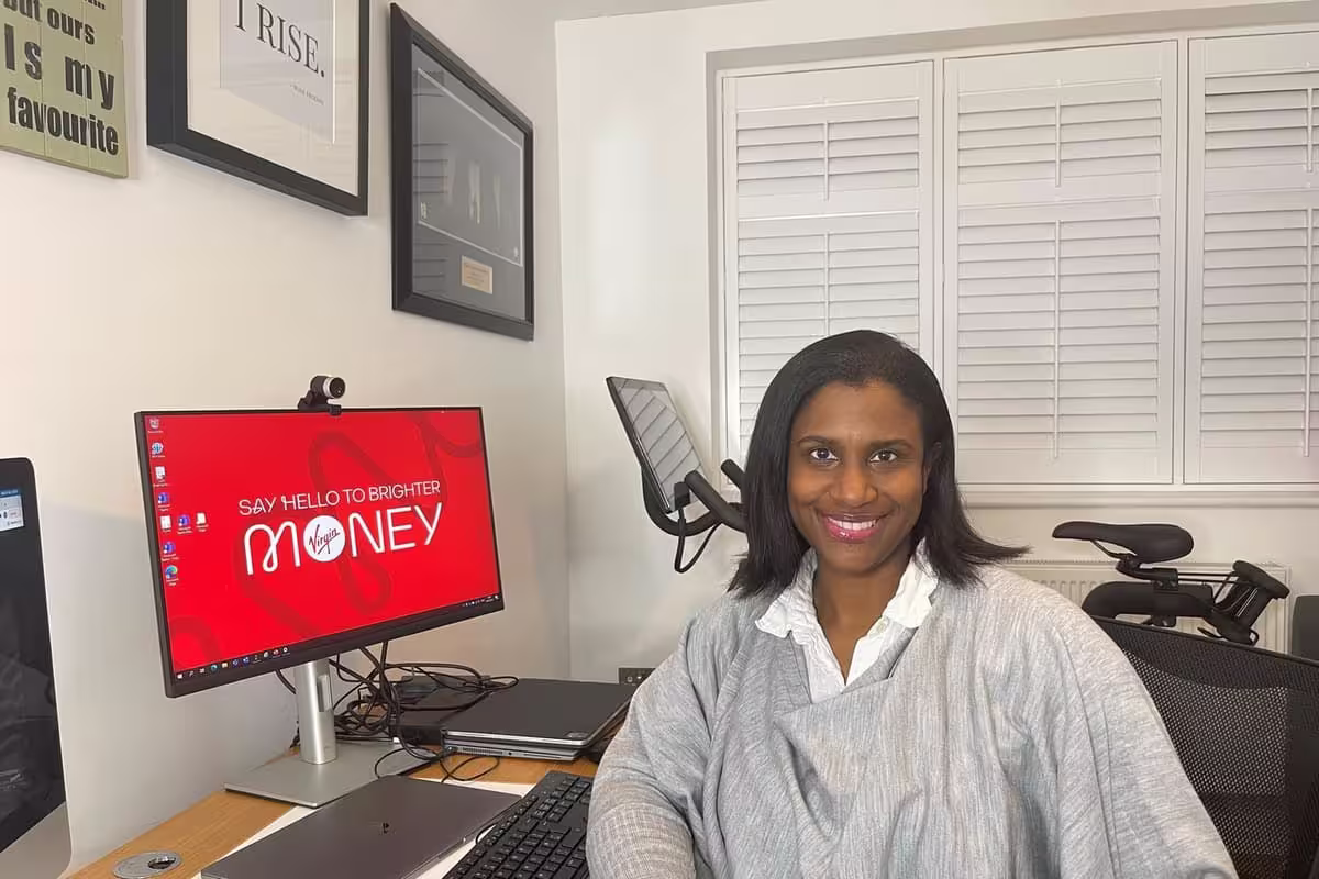 Syreeta Brown of Virgin Money sitting at her desk at her desk, sharing initiatives, business alignment, and organizational impact.