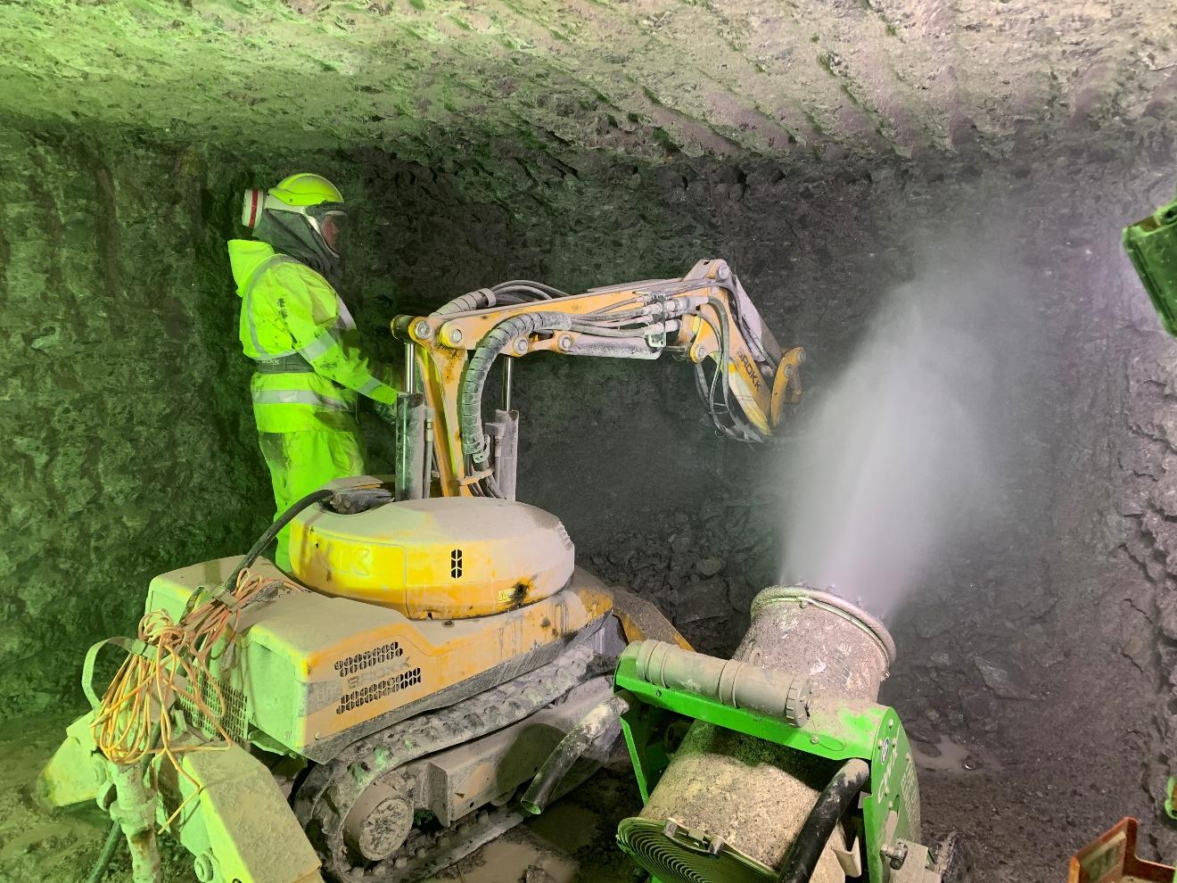 A worker in yellow PPE for wet dust suppression