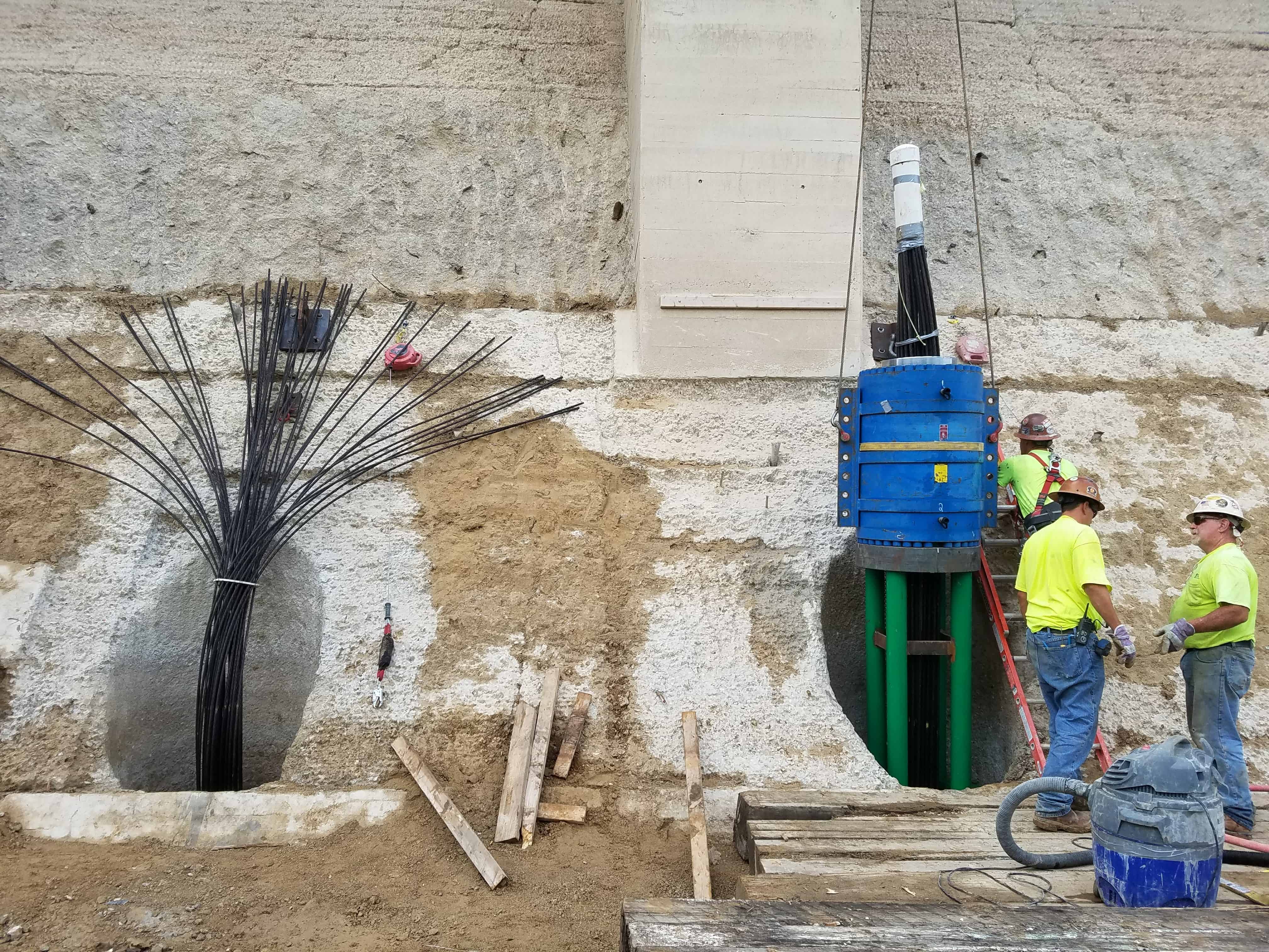 Two Team Members standing beside multistrand anchors at Bagnell Dam.