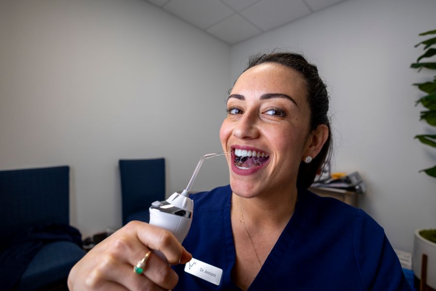 Dr. Annoni demonstrating how to use a waterpik