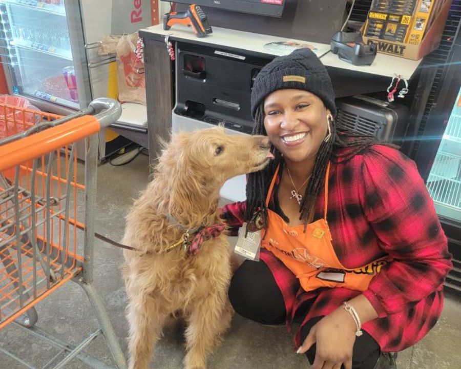 Angel smiling after getting her dental implants next to a cute dog