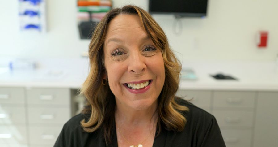 Kim Menzies smiling at Nuvia Dental Office before getting her new, permanent teeth
