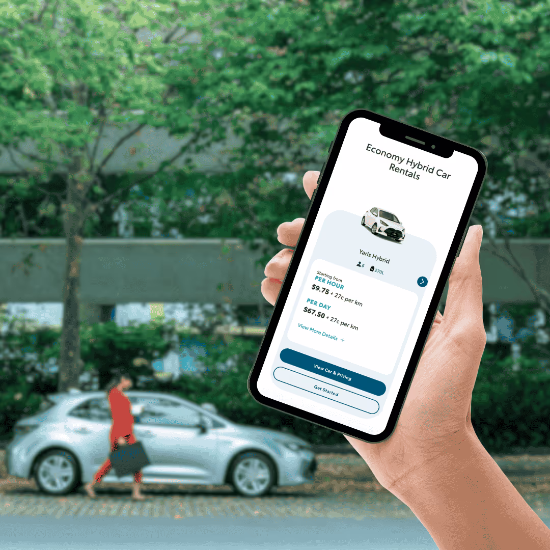 Hand holding smartphone with car booking app on screen
