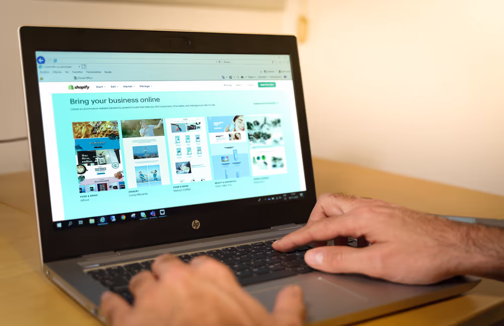 Business owner setting up a Shopify online store on a laptop