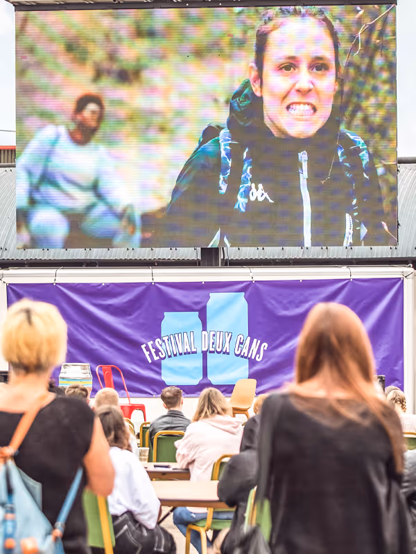 People seated in an outdoor cinema watching a film.
