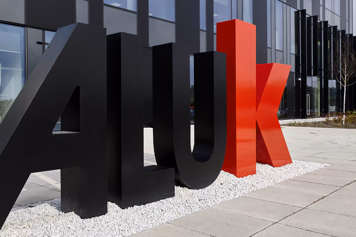Large AluK logo letters positioned in front of their office building.