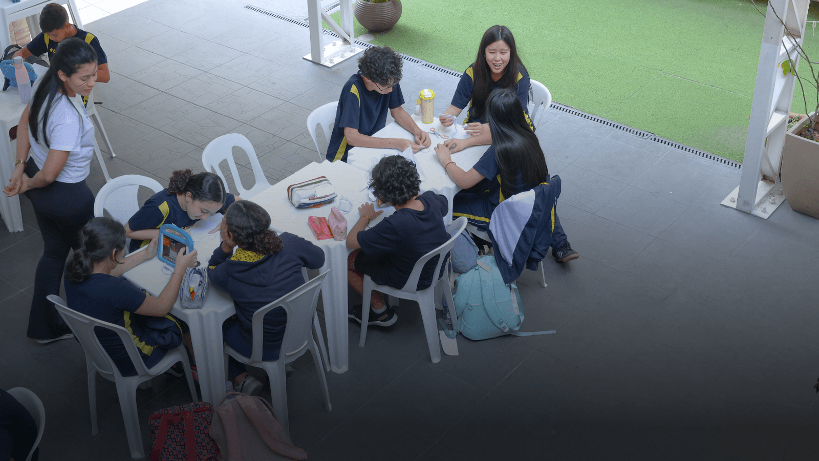 Alunos em atividade colaborativa com tablets e desenhos