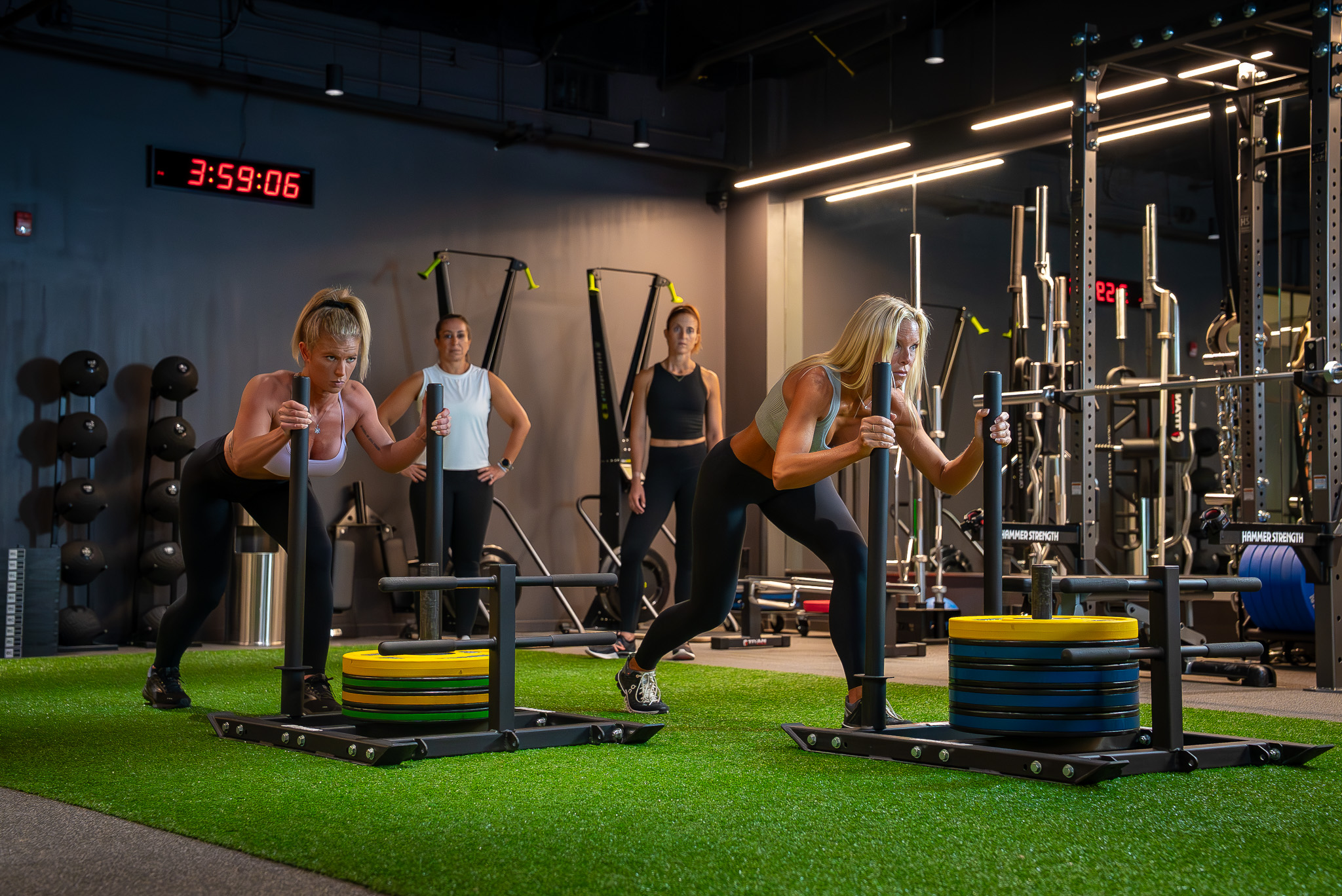 Member doing a sled push on the turf at FIELDHOUSE gym