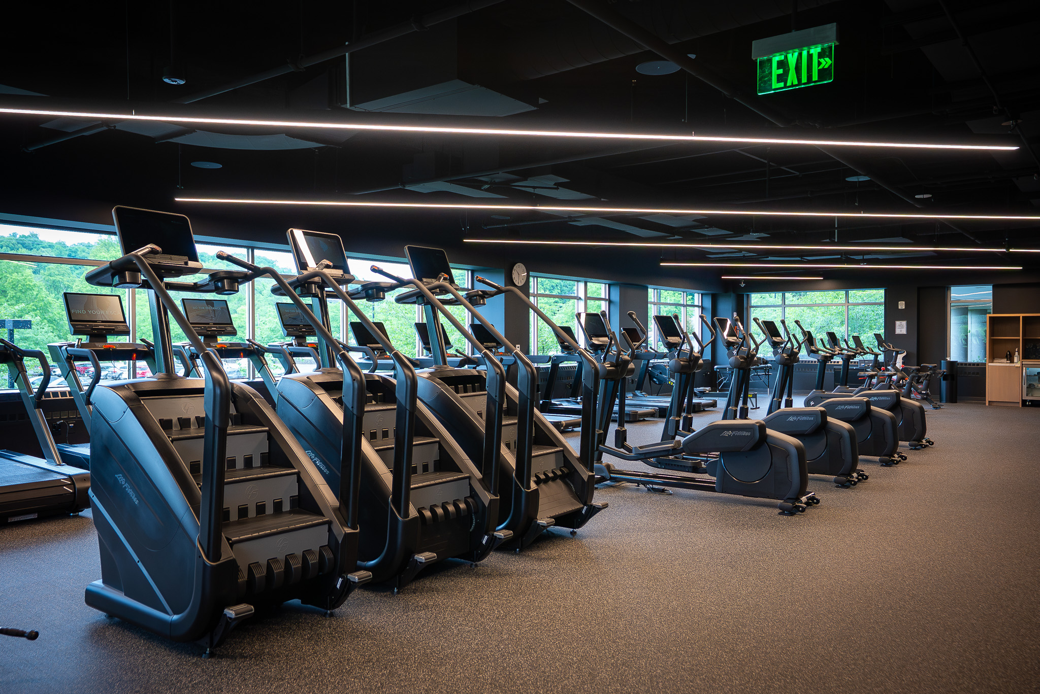 A wide variety of cardio machines at FIELDHOUSE gym, including tredmills, bikes, stair steppers, pelatons, and ellipticals.