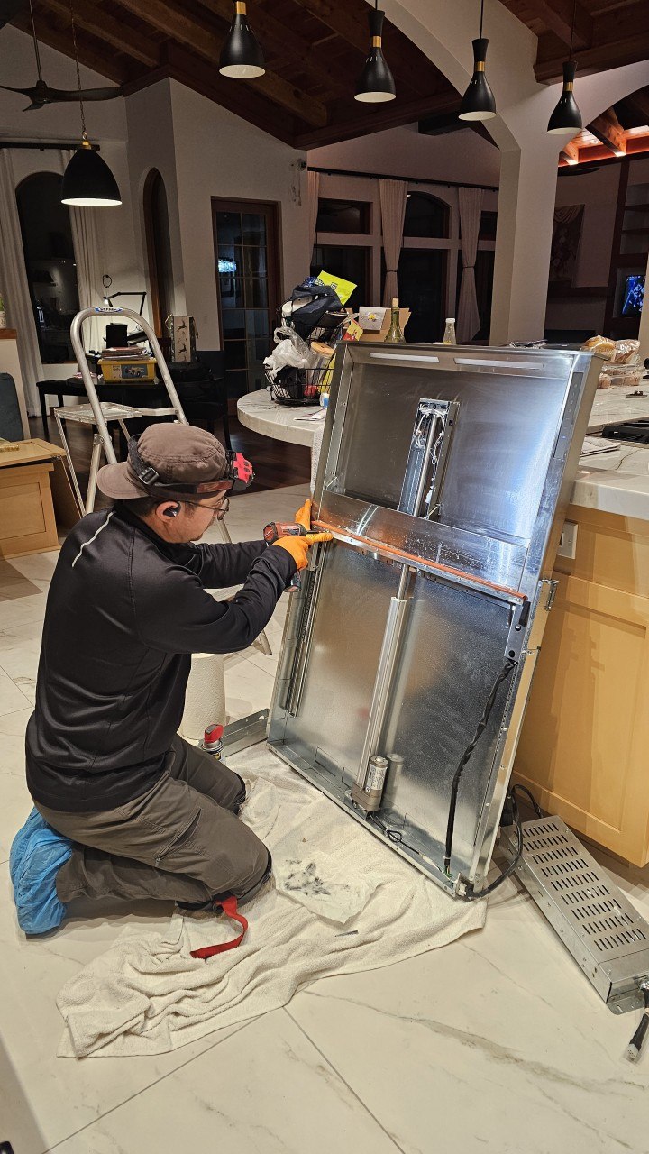 Jason Karzhaubay servicing a built-in appliance on-site