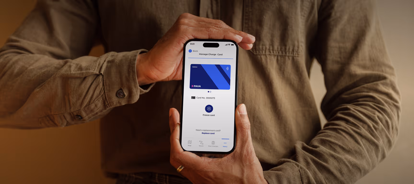 A person holds a smartphone showing the Paua app’s "Manage Charge Card" screen, prompting card details for verification.