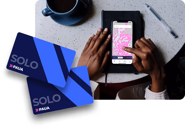 Hands touching and interacting with the Paua Solo app, with the map view showing on the screen next to a couple of Paua Solo cards, illustrating app-card interoperability