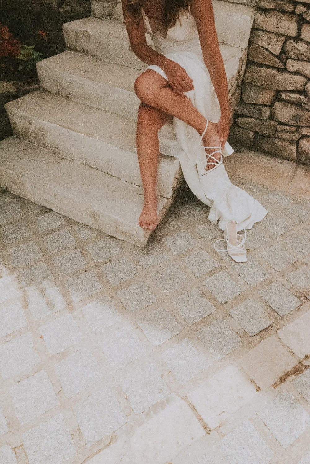 A bride in a white dress holding a bouquet of blue flowers on her wedding day.