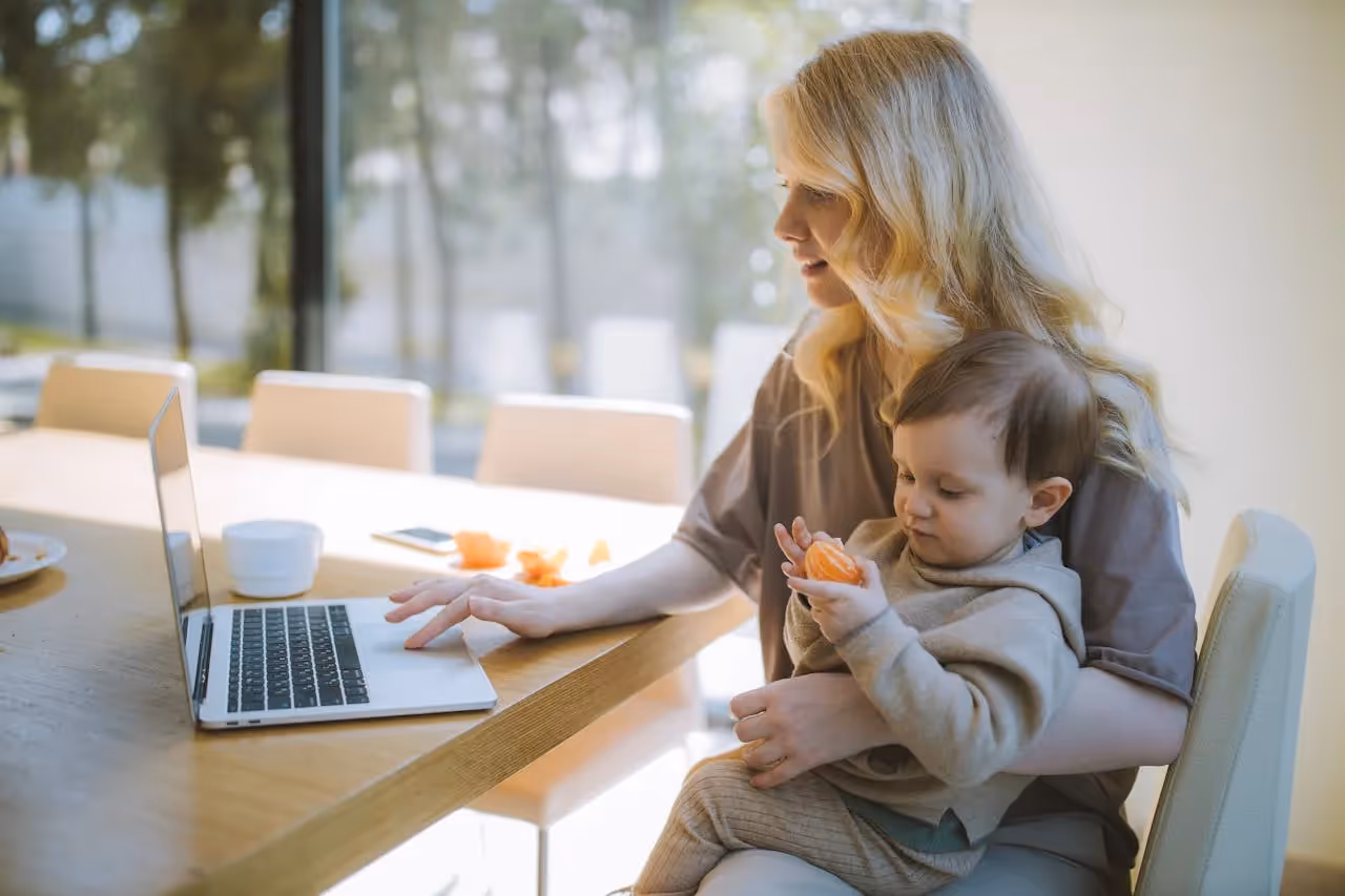 "A parent studying with child in background"