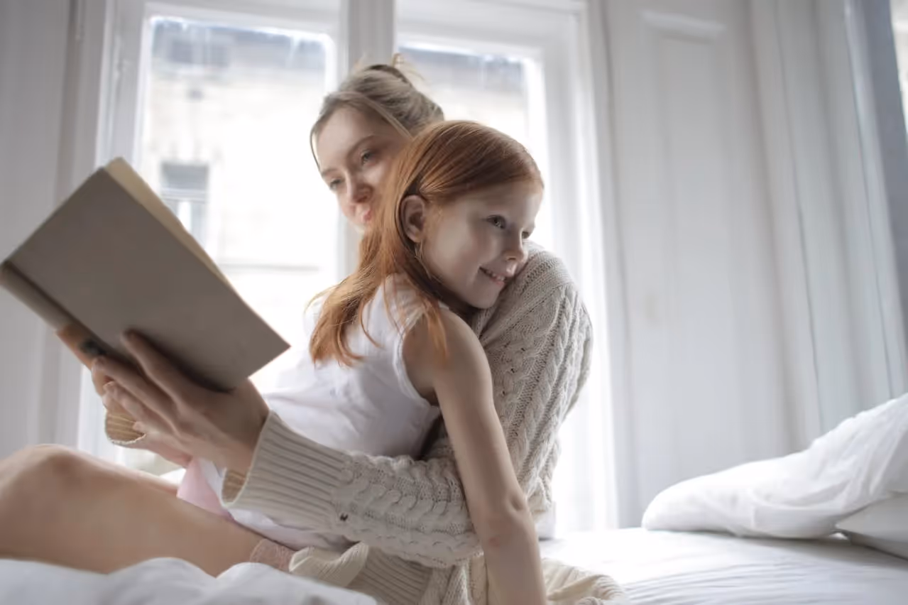 Mother and child studying together at a desk.