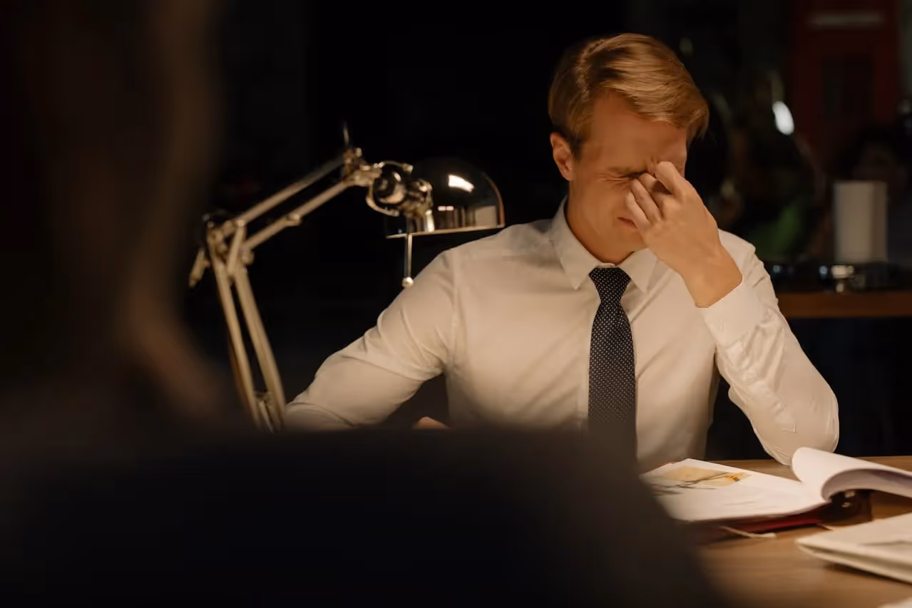 Detective working at desk with computer and case files.