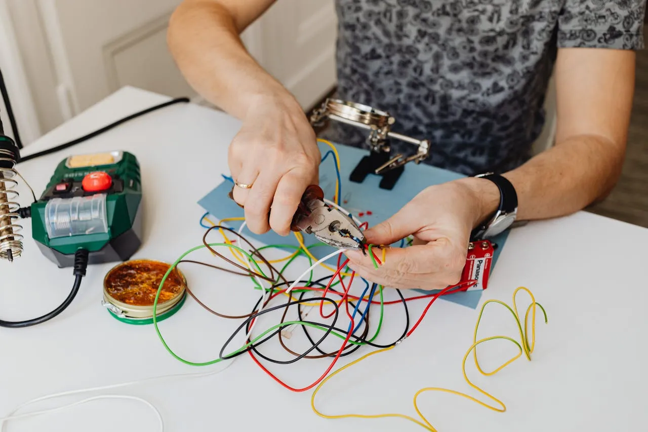 Electrician student working on wiring in a classroom at American Trade School.