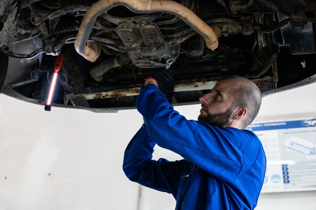 Automotive technician working on car engine.