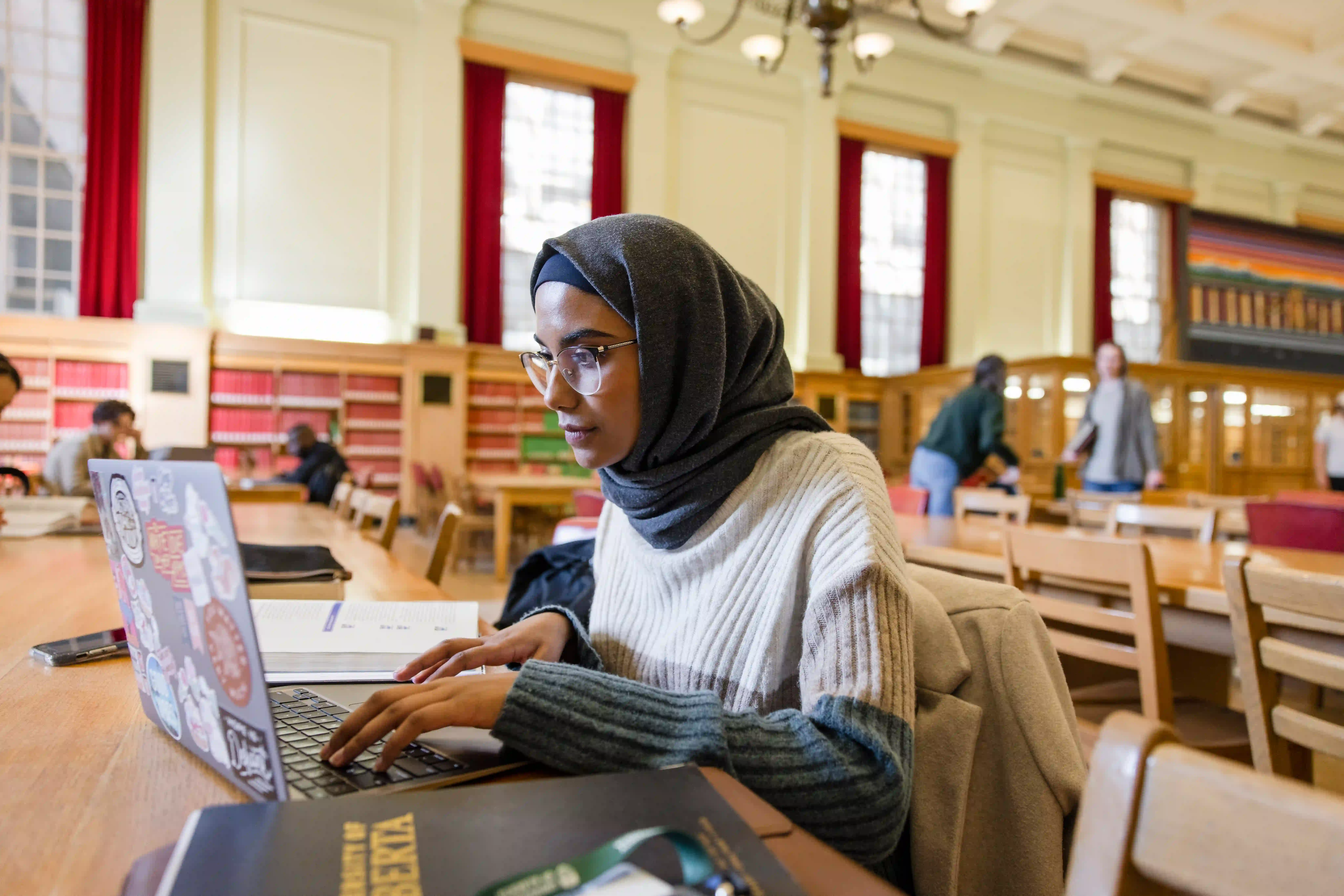 student studying on laptop at library